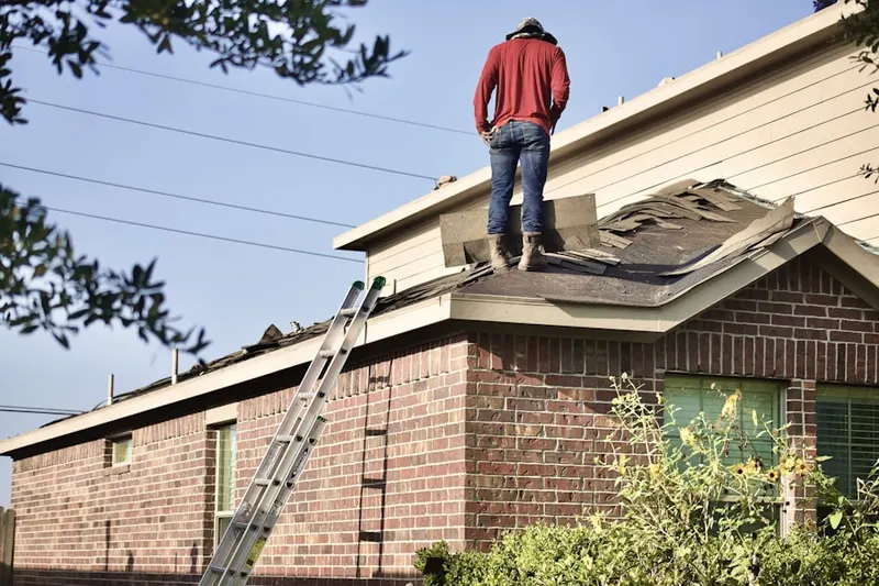 Professional roofer working on a residential roof in Logan Hills